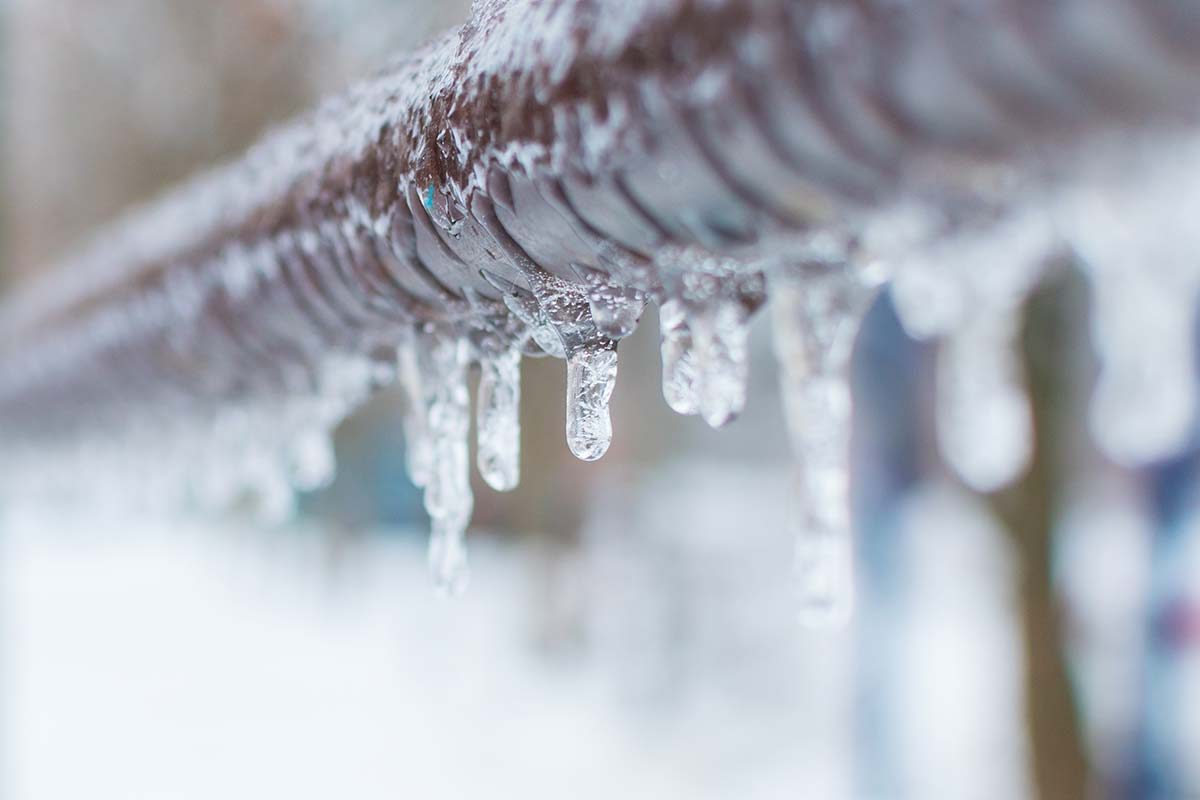 A frozen pipe dripping frozen water