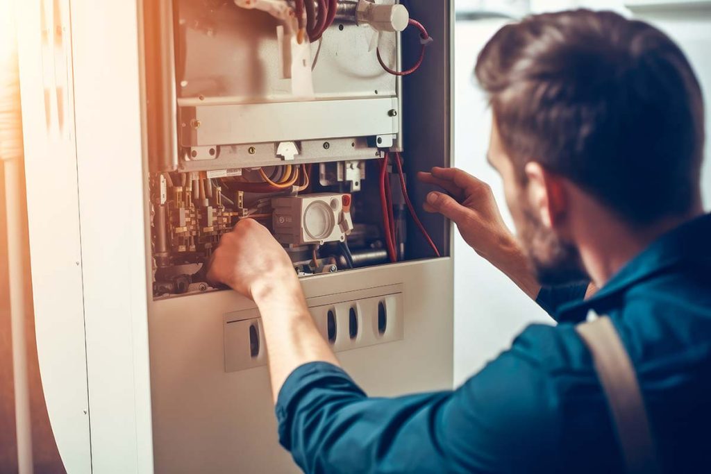 Professional inspecting a heating system, showcasing Lund Plumbing and Heating's dedicated heating services in Wakefield, Massachusetts.