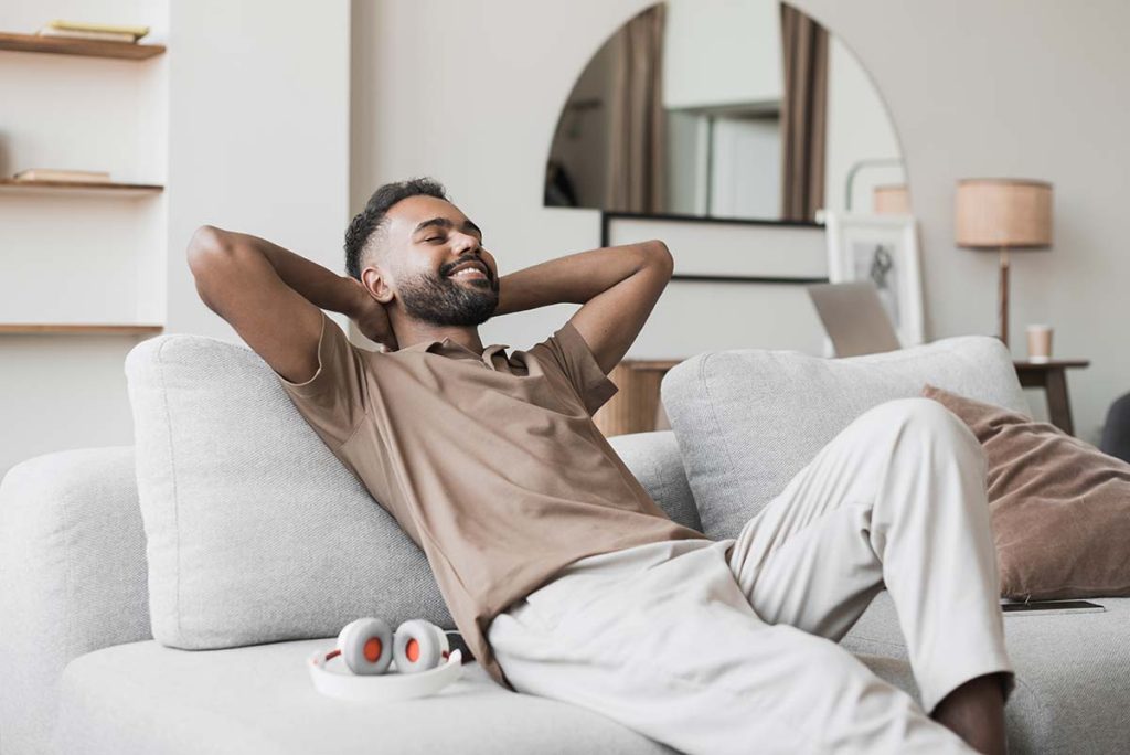 A man relaxing in his comfortable home, symbolizing the satisfaction of customers with Lund Plumbing and Heating's services in Winchester, Massachusetts.