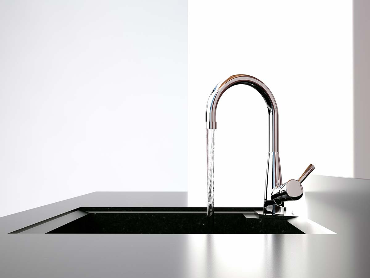 A close-up of a modern kitchen faucet installed by a professional kitchen plumber.