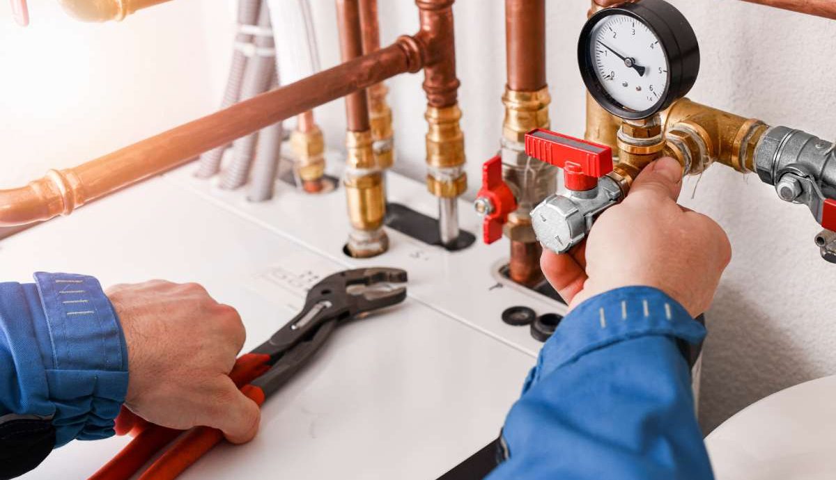 Plumbing concept or service water worker. copper pipeline of a heating system in technical room. Boiler and expansion expansion tank system, detail of pressure gauge.